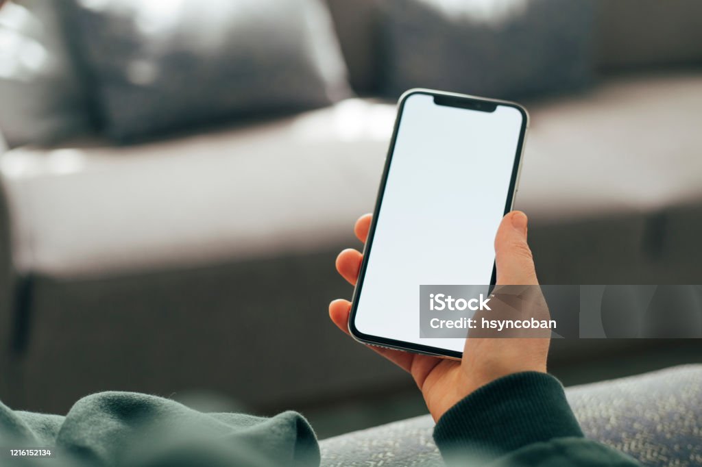 Mano sosteniendo teléfono inteligente en blanco - Foto de stock de Teléfono libre de derechos