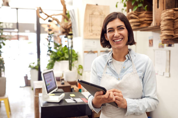 portret właścicielki z cyfrowym tabletem stojącym za biurkiem sprzedaży sklepu kwiaciarni - clothing store sales clerk usa clothing zdjęcia i obrazy z banku zdjęć