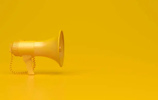 Photo of Monochrome yellow single megaphone. Loudspeakers on a yellow background. Conceptual illustration with copy space. 3D render.