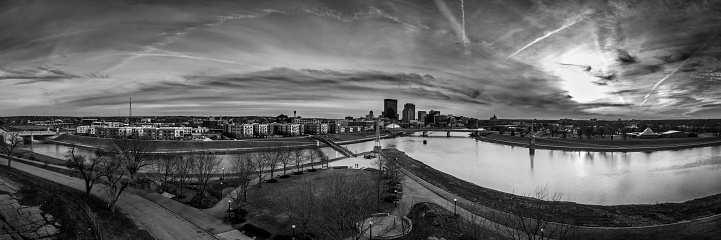 A 180 degree panoramic black and white aerial drone view of Dayton, Ohio from the confluence of the Great Miami and Mad Rivers in early spring.