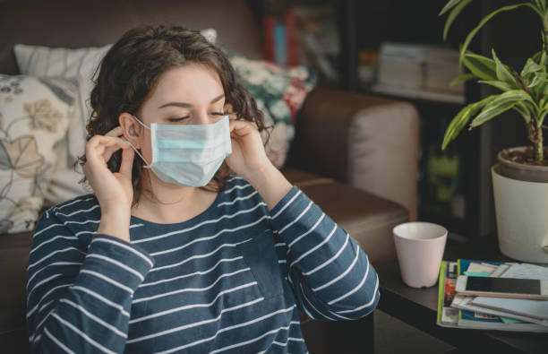 istock Beautiful young woman working at home ( in the mask) 1216152486