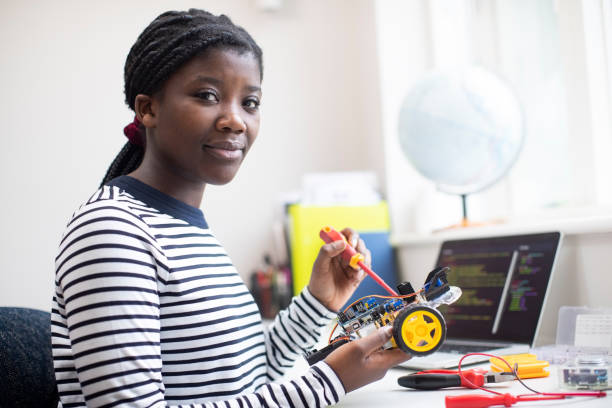 verticale d’une adolescente femelle construisant une voiture robotisée dans la leçon de science - collégienne photos et images de collection