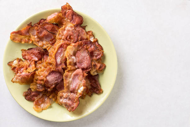 istock Crisp fried bacon on the plate above white marble background table 1216160069