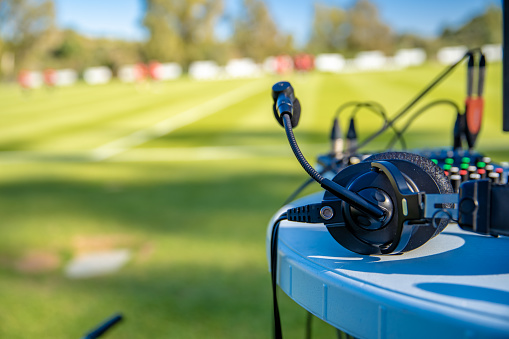 auriculares de comentaristas en la mesa junto al campo de fútbol. transmisión para televisión y radio photo