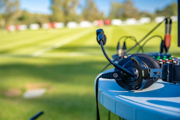 commentator headsets on the table next to the football field. stream for television and radio commentators on football game watching match. stream for television and radio. commentator photos stock pictures, royalty-free photos & images