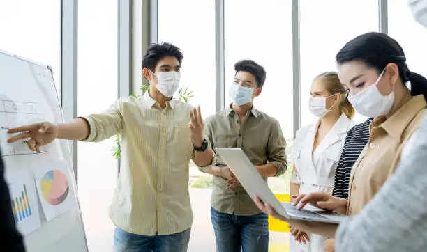 Photo of Group of asian business people meeting and working in office and wear mask for protect  prevent infection corona virus covid 19.