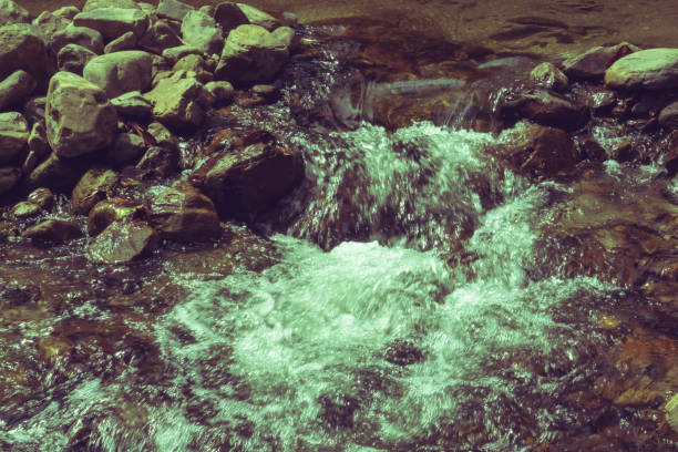 water flowing over boulders, rocks, and stones