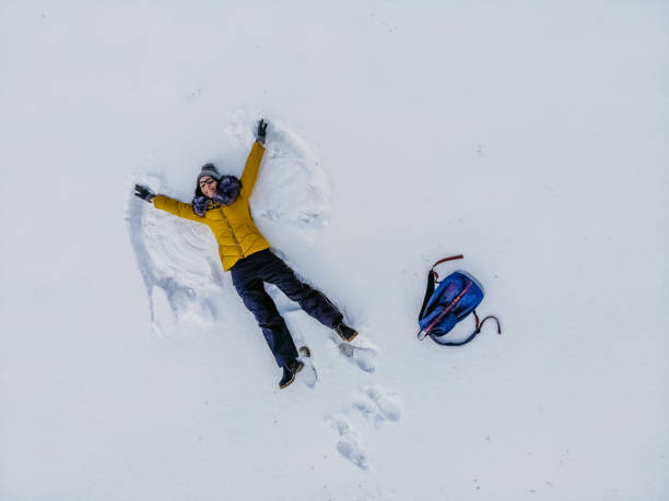 istock Aerial view woman making snow angel 1216171494