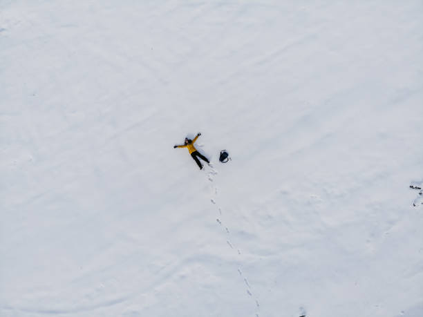 istock Aerial view woman making snow angel 1216171530