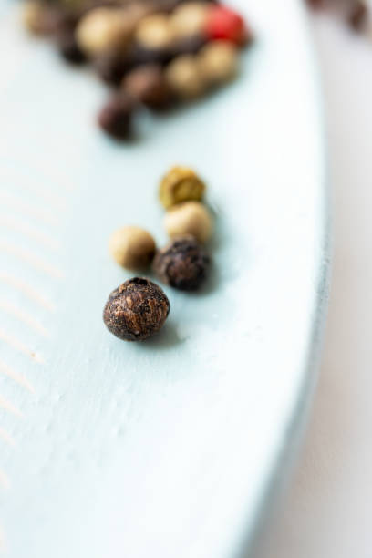 istock Macro black peppercorn dry spice on saucer with selective focus. Various peppers, close-up. Details food 1216176649