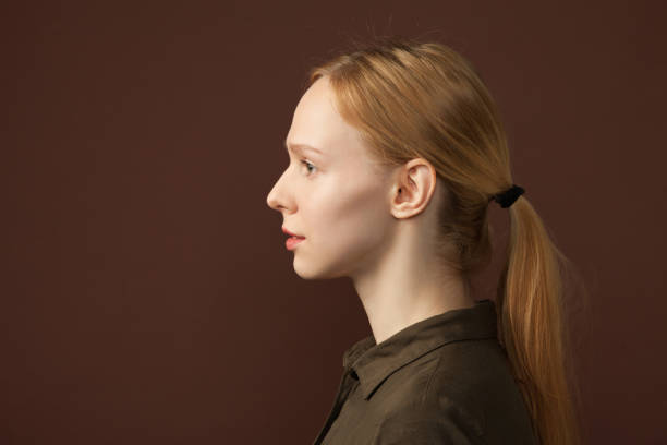 студийный портрет 25-летней женщины на коричневом фоне - волос назад стоковые фото и изображения