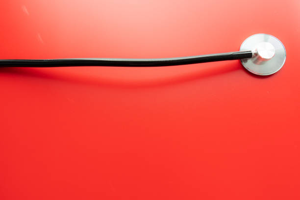 istock Close up of a stethoscope isolated on red background 1216177091