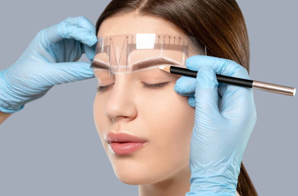 permanent make-up für augenbrauen der schönen frau mit dicken brauen in schönheitssalon. nahaufnahme kosmetikerin tun tätowierung augenbraue. professionelle make-up und kosmetik hautpflege. - removing tweezing eyebrows eyebrow caucasian stock-fotos und bilder