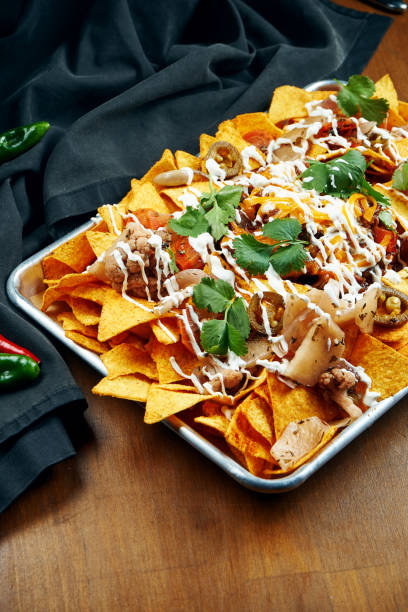 istock Nachos - A classic Mexican appetizer made from corn tortilla chips. Nachos with sauces and holopenya. Top view. Close up. 1216180003