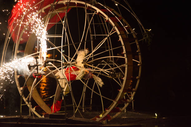 performer riding a ferris wheel on the water - carnival amusement park amusement park ride traditional festival imagens e fotografias de stock