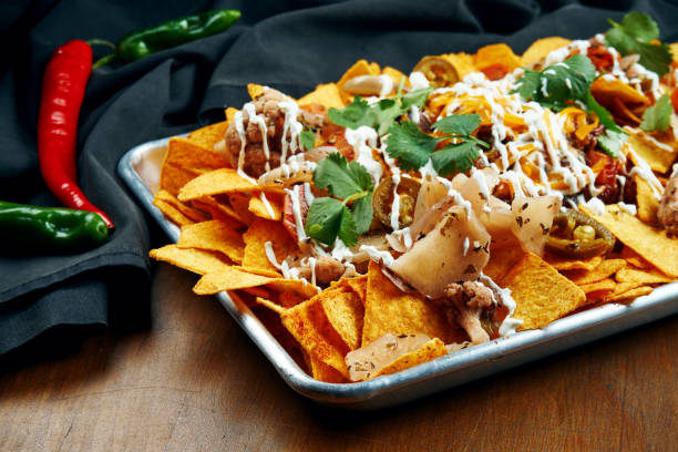 istock Nachos - A classic Mexican appetizer made from corn tortilla chips. Nachos with sauces and holopenya. Top view. Close up. 1216180253