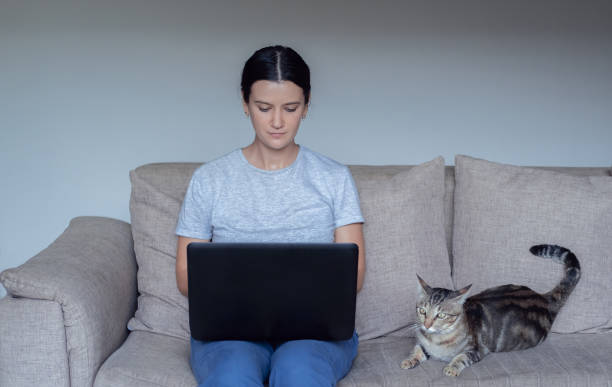 istock Young woman using her laptop on sofa working online, watching movie or studying remotely. Work from home due to corona virus covid-19 epidemic outbreak 1216180875