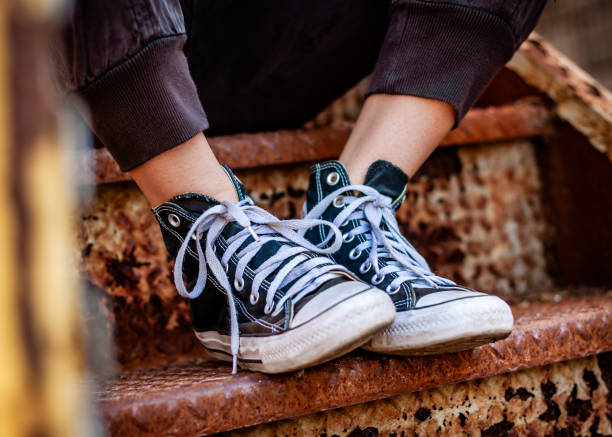 Black shoes on a staircase Teenage girl wearing black shoes on a rusty staircase. high tops stock pictures, royalty-free photos & images