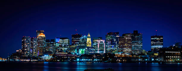 Panoramic Night Cityscape Boston Skyline over Boston Harbor View of downtown Boston buildings and skyline over Mystic River in Massachusetts east boston stock pictures, royalty-free photos & images