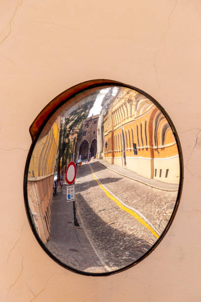 Via Fratelli Cairoli or Fratelli Cairoli Street distorted reflection in a traffic convex mirror in Mantova or Mantua, Lombardy, Italy