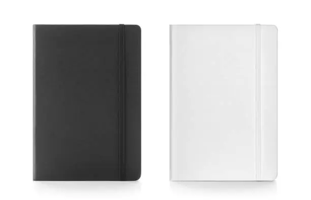 Photo of Black & white colour leather fabric hardcover notebook with elastic band. Top view with notebook closed & open. Line sheet. Isolated on white background.
