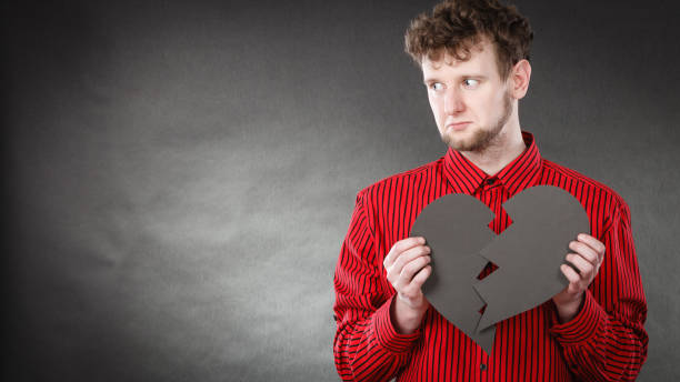 istock Young depressed man covered by broken heart. 1216187110