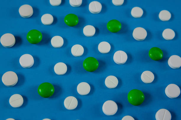 istock many white and green pills on a blue background 1216187814