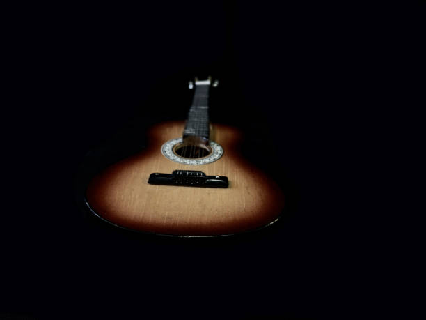 istock Six-stringed acoustic guitar on a black background. Musical string instrument. Guitar fretboard. 1216188260