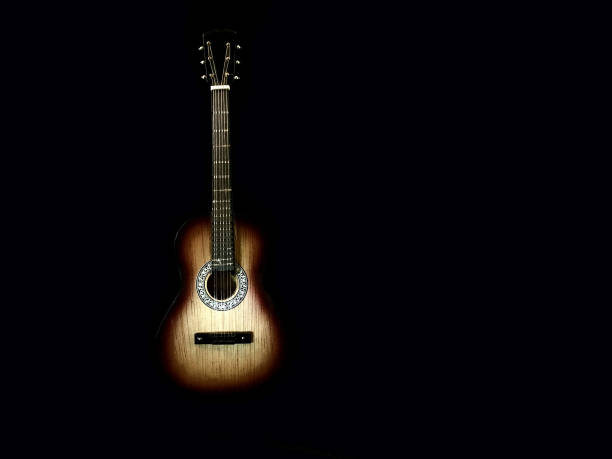 istock Six-stringed acoustic guitar on a black background. Musical string instrument. Guitar fretboard. 1216188274
