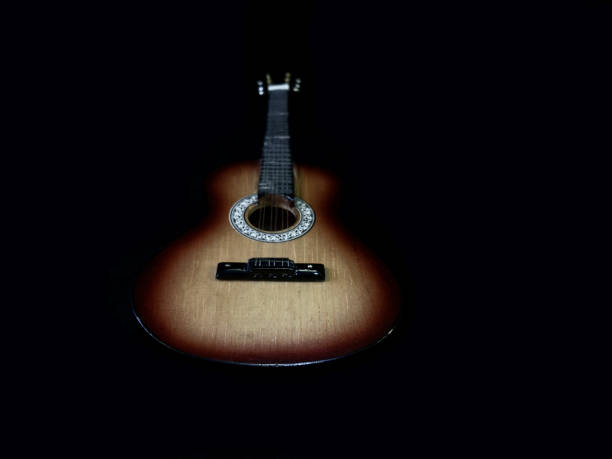 istock Six-stringed acoustic guitar on a black background. Musical string instrument. Guitar fretboard. 1216188296