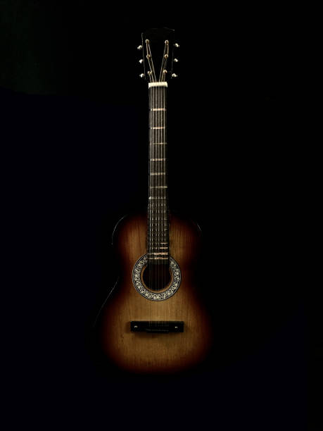 istock Six-stringed acoustic guitar on a black background. Musical string instrument. Guitar fretboard. 1216188393