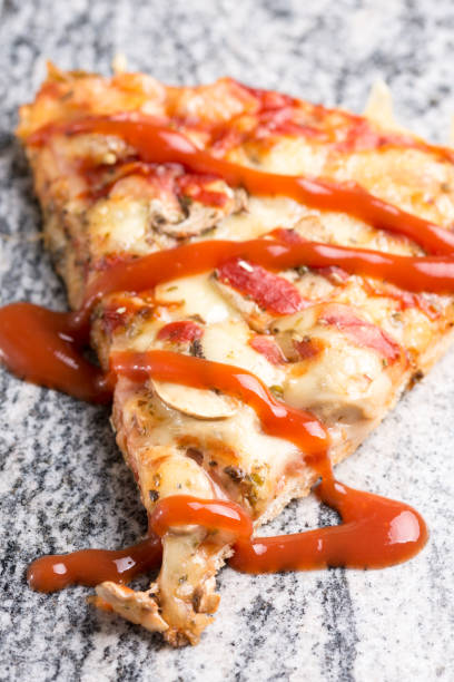 istock Pizza slice with mushrooms ham cheese and ketchup on the grey granite background 1216191508