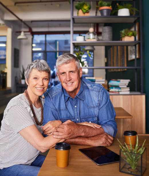 istock Mature couple smiling while sitting together at a cafe table 1216191796