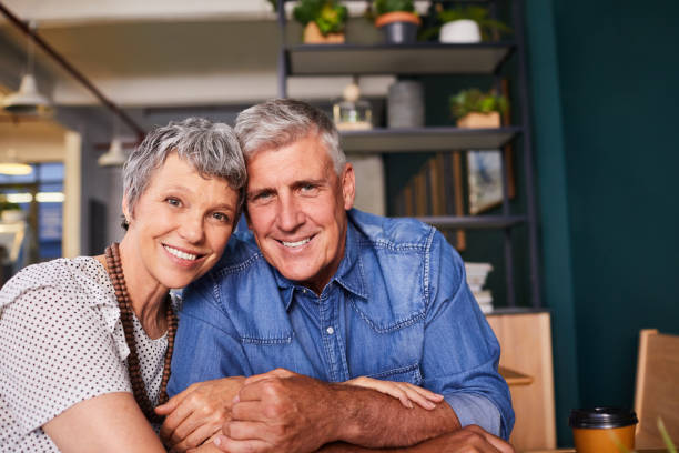istock Mature couple smiling while sitting together at a cafe table 1216192174