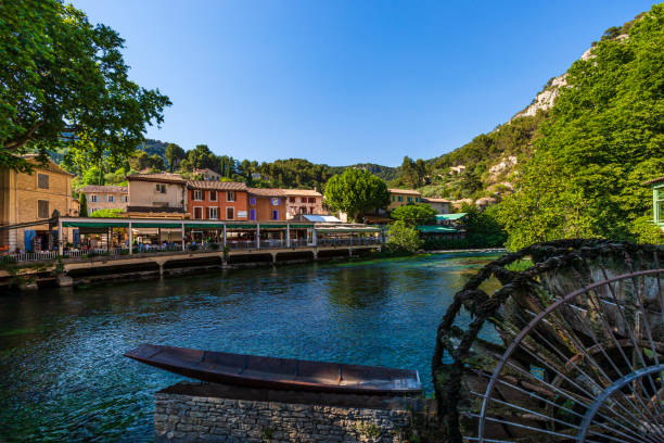 Fontaine de Vaucluse is a small town located next to the source of the Sorgue River. In the foreground is one of the several old water wheels.