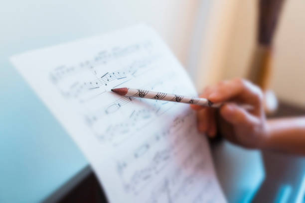 Horizontal detail of teacher explaining correct music lecture of piano score. Unrecognizable woman teaching piano lessons at home. Create music and songs concept. Leisure and hobby indoors. sheet music photos stock pictures, royalty-free photos & images