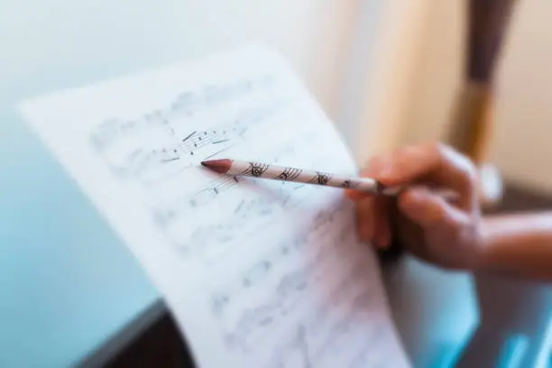 Photo of Horizontal detail of teacher explaining correct music lecture of piano score.
