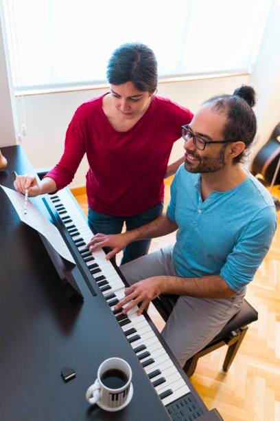 istock Vertical aerial view of man practicing musical lessons indoors. 1216192261