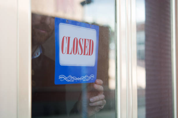istock Business man hanging closed sign 1216193314