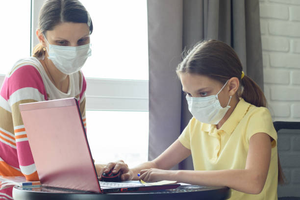 istock Girl does homework online, mom is watching nearby 1216193787