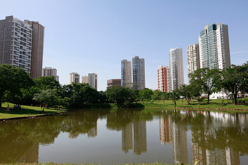 Water reflects residential buildings close to the park in Goiania, Goias, Brazil