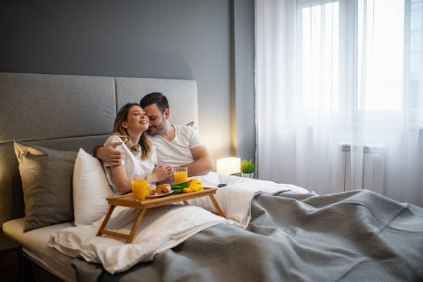 Happy couple having a breakfast in the bed stock photo