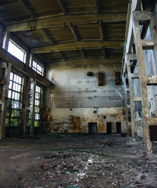 istock Large abandoned industrial hall. Dangerous area. Abandoned industrial interior with bright lights. Exclusion zone, radiation risk, lost city, apocalyptic building 1216197077