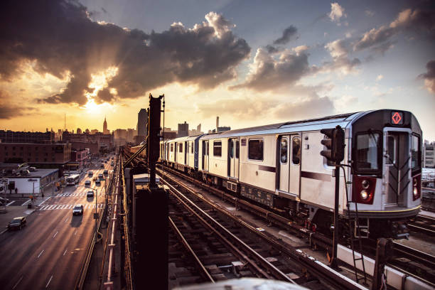 train de métro surélevé et horizon de new york city - subway train photos et images de collection