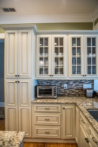 istock A square shaped green kitchen with cream colored cabinets in a new construction home with granite countertops and lots of cabinets and storage space 1216197855