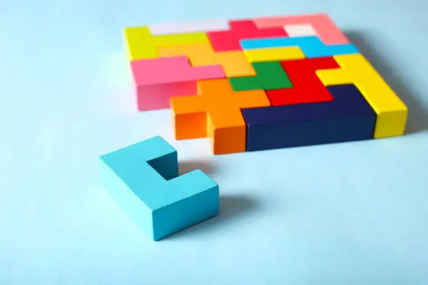 Simple solutions to solve problems. Strategy in business. Wooden game cubes on a blue background as a puzzle symbol. The challenge with a difficult solution