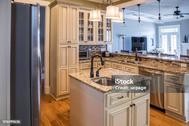 A Square Shaped Green Kitchen With Cream Colored Cabinets In A New Construction Home With Granite Countertops And Lots Of Cabinets And Storage Space Stock Photo - Download Image Now