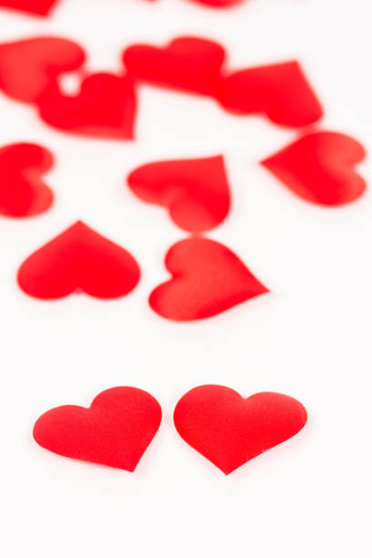 istock Two red hearts isolated on white background with red hearts in the background 1216204045