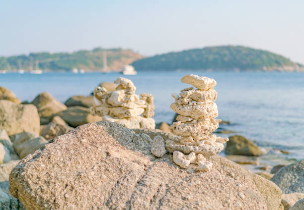 Pyramid of beach pebbles and coral on granite stones. Thailand. Phuket