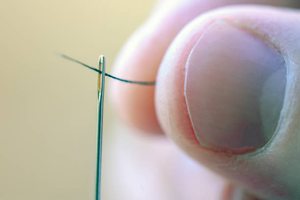 enhebrar una aguja de coser - thread needle sewing isolated fotografías e imágenes de stock